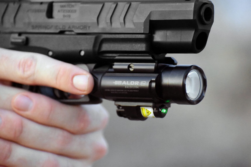 picture of a man hands holding gun with military olight torch flashlight 