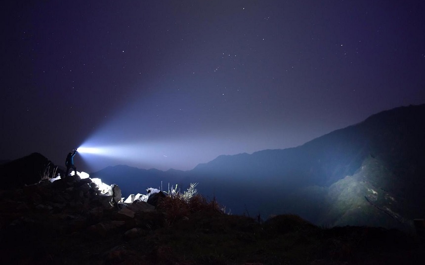 picture of a man on the mountains wit a military torch flashlight