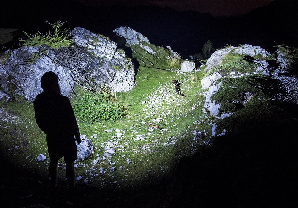 picture of a person with a olight military flashlight in the mountains
