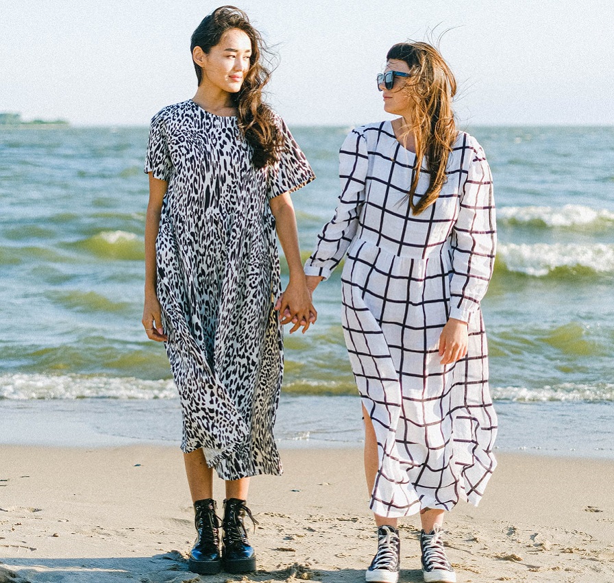 picture of two woman wearing long dresses on a beach 