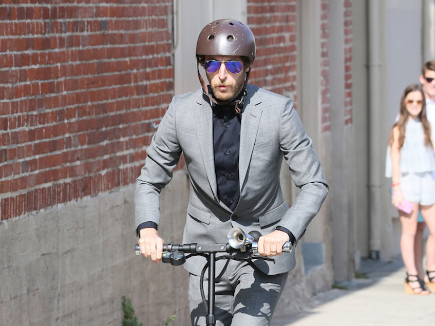 Man riding scooter and wearing helmet