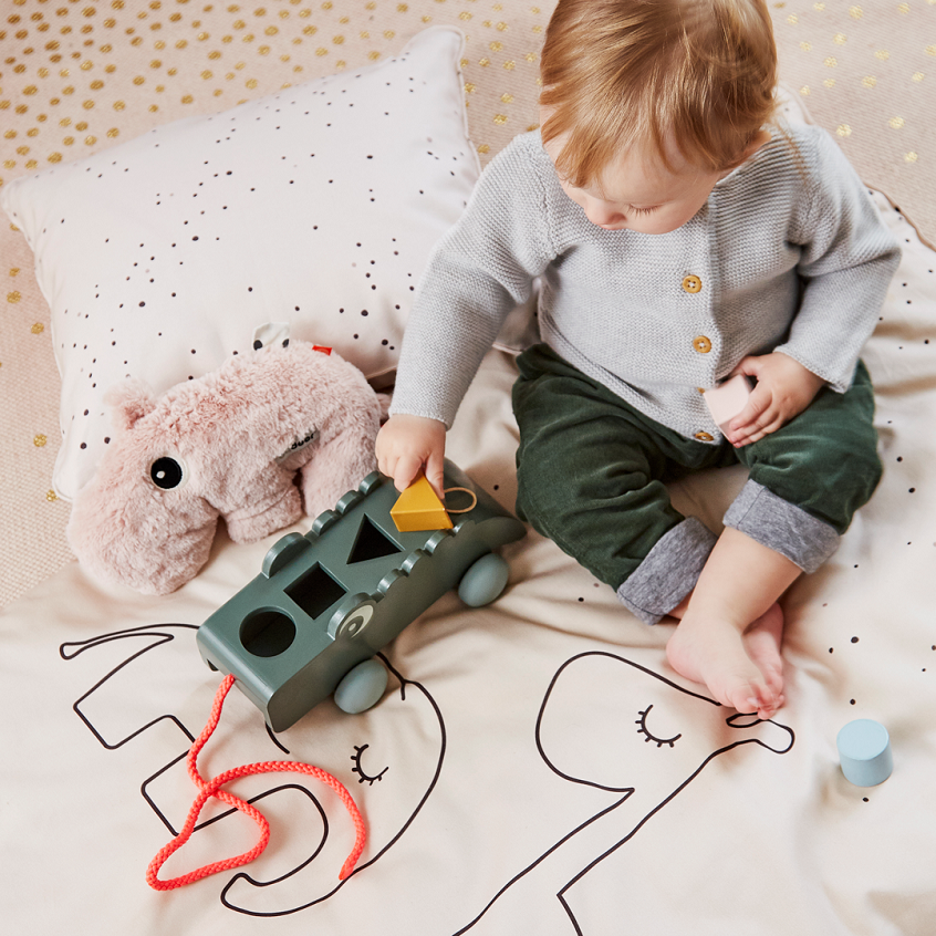 baby playing on bed with infant toys 