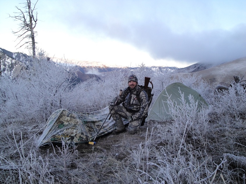 Hunter with his bivy bag on a snowy terrain 