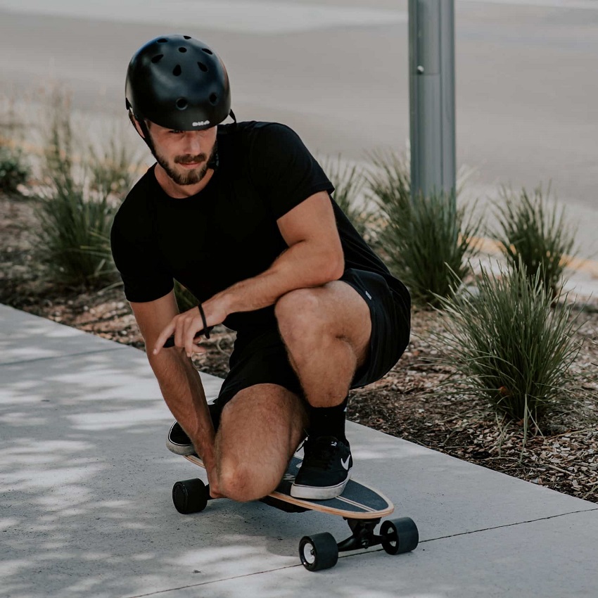 picture of a men skateboarding on the sidewalk 