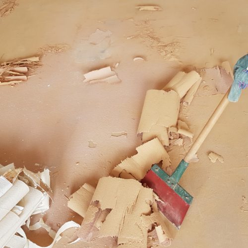 home renovation - removing the old floor covering with a scraper