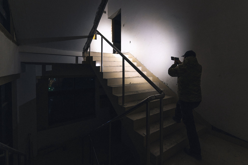 man holding a gun with its flashlight on